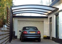 a car parked in front of a house with a metal roof over the garage door