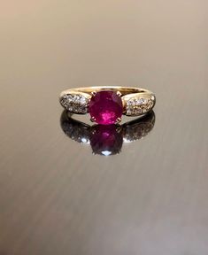 DeKara Designs Collection Metal- 18K Yellow Gold, .750. Stones- 1 Oval Ruby 1.05 Carats, 14 Round Diamonds G-H Color VS2 Clarity 0.25 Carats. Art Deco 18K Yellow Gold Ruby Diamond Engagement Ring. This ring features a beautiful reddish pink ruby that is professionally set in between four prongs. There are seven pave set diamonds on each side of the ruby. The yellow gold and the ruby compliment one another beautifully and the diamonds are the perfect finish to this amazing ring. Size- 7 1/2. FREE Luxury Yellow Gold Ruby Ring With Diamond Accents, Luxury Ruby Ring With Diamond Accents In Yellow Gold, Luxury Ruby Ring With Diamond Accents And Round Shape, Luxury Yellow Gold Ruby Ring With Center Stone, Luxury Round Ruby Ring With Diamond Accents, Gia Certified Oval Ruby Ring For Wedding, Gia Certified Ruby Diamond Ring For Anniversary, Dazzling Ruby Anniversary Ring, Classic Gia Certified Round Ruby Ring