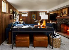 a living room filled with furniture and a fire place next to a table covered in books