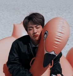 a man sitting on top of an inflatable animal with his face close to the ground