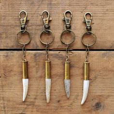 four different types of key chains hanging on a wooden wall with some animal horns attached to them