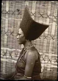 an old photo of a woman with a large head piece on it's head