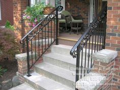 an iron stair railing on a brick house