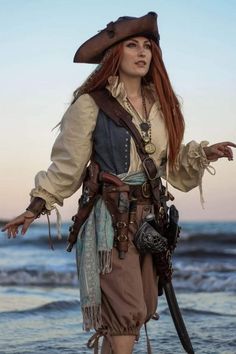 a woman dressed in pirate costume on the beach