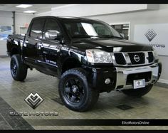 a black truck is parked in a showroom