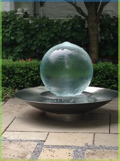 a metal bowl sitting on top of a stone walkway