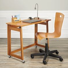 a wooden desk with a laptop computer on top of it and a chair next to it