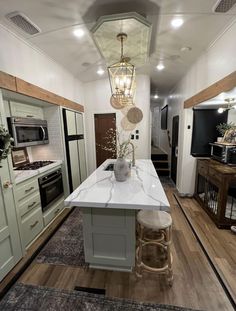 a kitchen area with an island, stove and sink in the middle of the room