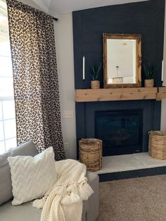 a living room with a couch, fireplace and mirror