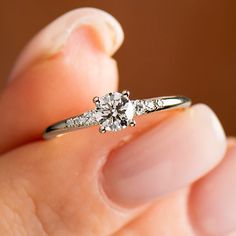 a person holding a diamond ring in their hand