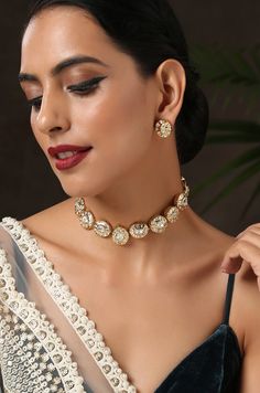 This choker necklace set is an edgy piece with a geometrical deisgn. The timeless kundan in a backdrop of glorious gold plated silver alloy is a very pretty modern piece. Necklace Closure - Adjustable Dori Earrings Closure - Push Back Style Tip - Versatility and elegance being the strong suit, we leave a lot to your imagination for how you want to dress your jewels your way and embracing your personal style. This pretty is made for a modern day woman who has her heart in the little details of he Bollywood Kundan Necklace For Party, Gold Plated, Gold Plated Kundan Necklace Bollywood Style For Party, Bollywood Style Gold Plated Kundan Necklace For Party, Meenakari Choker Necklaces For Parties, Gold Metal Necklaces For Diwali, Gold Plated Bridal Choker Necklace, Gold Temple Necklace For Diwali Party, Wedding Brass Choker Necklace, Gold Kundan Necklace For Party