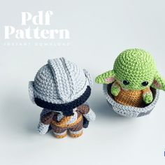 two crocheted yoda and baby yoda dolls sitting next to each other