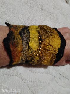 a person's arm covered in yellow and black paint with gold flecks