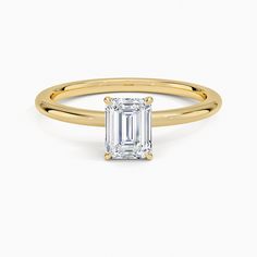 a gold ring with an emerald cut diamond