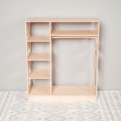 a wooden shelf sitting on top of a tiled floor next to a white wall with geometric designs