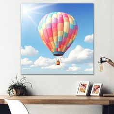 a colorful hot air balloon floating in the sky above a table with pictures on it