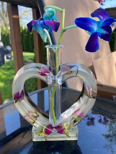 a glass vase with flowers in it sitting on a table