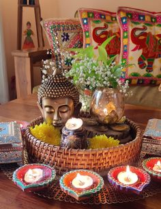 there is a buddha statue sitting on the table with candles in front of it and other decorations around it