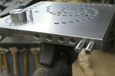 a metal table with holes and screws on it