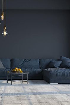 a living room with a blue couch and coffee table in front of a black wall