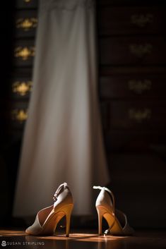 the bride's shoes are sitting on the floor in front of her wedding dress