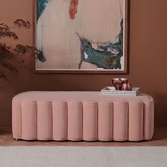 a painting hangs on the wall above a pink bench in front of a white rug