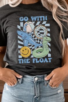 Make a splash with our "Go With The Float" Pool Toys Graphic Tee in blue. This eye-catching tee features a playful design of colorful pool toys, including floaties, beach balls, and rubber ducks. Most t shirt colors are 52/48 cotton/poly blend. White and Cream tees are 100% cotton, Ash tees are 99/1 cotton/poly. Perfect for beachwear stores, water parks, and summer-themed events, this trendy graphic tee is a must-have for those looking to add a touch of fun to their wardrobe. By Kissed Apparel.M Fun Letter Print T-shirt For Summer, Fun Graphic Print T-shirt For Summer Activities, Fun Cotton T-shirt For Summer Activities, Casual T-shirt With Funny Print For Playtime, Summer Funny Print T-shirt For Playtime, Fun Short Sleeve T-shirt For Summer Activities, Trendy Graphic Print T-shirt For Summer Activities, Playful Tops For Beach Season Playtime, Graphic Tee T-shirt For Summer Playtime