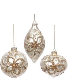 three glass ornaments with gold and white designs on them, one is hanging from the ceiling