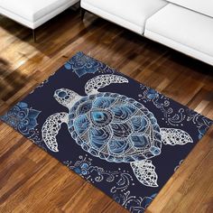 a blue and white rug with a turtle on it's back in front of a couch