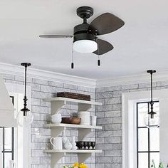 a ceiling fan is hanging from the ceiling in a room with white brick walls and flooring