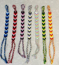 five different colored braided lanyards on a white surface