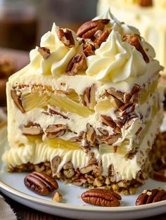 a piece of cake with white frosting and pecans around it on a plate