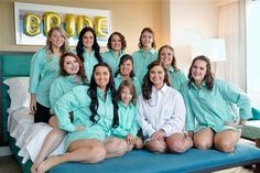 a group of women sitting on top of a blue bed in front of a window