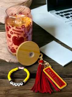 a jar of candy and two bracelets sitting on a table next to a laptop