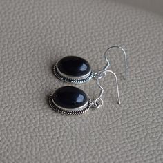 Gemstone-Black Onyx Shape-Oval Stone Size-10x14 MM Metal-925 Sterling Silver This One of a kind earrings is adorned with beautiful Black Onyx gemstone in sterling silver.Black Onyx is the birthstone representing the month of December. About gemstone- Black Onyx is the birthstone for Leo. It is the stone of protection.This elegant smooth textured stone is said to have immense healing and spiritual benefits.Black Onyx symbolizes peace,harmony and love and good luck.Black Onyx is well known to remo Black Oval Earrings For Formal Occasions, Black Oval Pierced Earrings, Black Oval Handmade Earrings, Classic Black Oval Earrings, Black Onyx Oval Earrings, Black Sterling Silver Jewelry With Oval Cabochon, Black Oval Cabochon Sterling Silver Jewelry, Oval Onyx Earrings For Gifting, Nickel-free Black Oval Jewelry