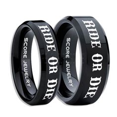 two black wedding rings with white lettering on the inside and outside, one for each other