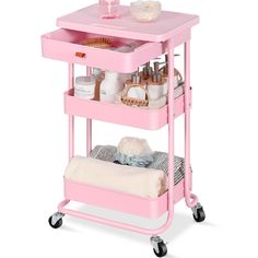 a pink cart with two drawers and some items on it