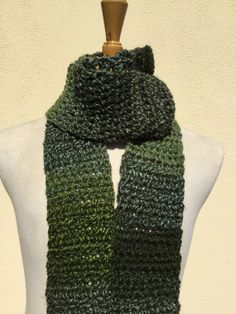 a green and black knitted scarf on a mannequin