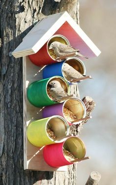 a bird house that is hanging from a tree with birds in it's holes