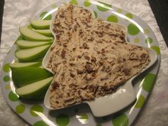 a plate topped with sliced apples and hummus on top of a polka dot table cloth