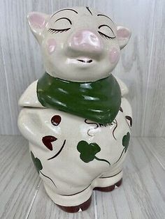 a ceramic pig figurine with a scarf around its neck