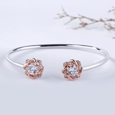 Surround her with flowers all year long. Buy that special someone this silver flower bangle, whether she is celebrating a holiday or if she is just a lover of flowers. Crafted in two tone sterling silver, the bangle consists from two blossoms on the two ends and a high polished bangle, which shows simple elegance. The cuff bangle is easy to adjust the size to fit for her wrist. Surprised her with this charming piece.Carat Weight: 3 ctStone Size: 6 mmNumber of Stones: 2 Stone Shape: RoundStone Co Rose Gold Bangle For Anniversary In Fine Jewelry Style, Rose Gold Bangle For Anniversary, Fine Jewelry, Rose Gold Bangle For Anniversary In Fine Style, Rose Gold Fine Jewelry Bangle For Anniversary, Elegant Cuff Bracelet For Promise, Fine Jewelry Rose Gold Cuff Bracelet For Anniversary, Rose Gold Cuff Bracelet For Anniversary, Rose Gold Cuff Bracelet For Wedding, Rose Gold Flower Shaped Bracelets For Wedding