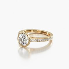 a yellow gold engagement ring set with a round diamond in the center and side stones on each band