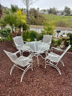 a white table and chairs sitting on top of mulch