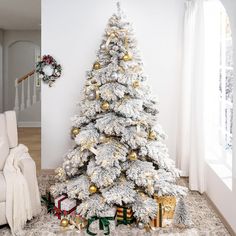 a white christmas tree with gold and silver ornaments