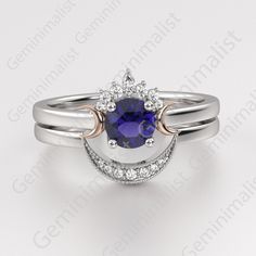 a white gold ring with a blue sapphire and diamonds on the sides, set against a white background