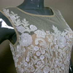 a mannequin wearing a dress with white flowers on it's neckline