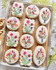 decorated cookies on a cooling rack with flowers