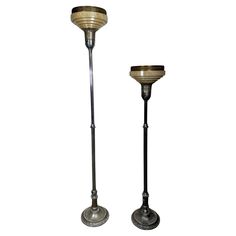 two metal candlesticks sitting next to each other