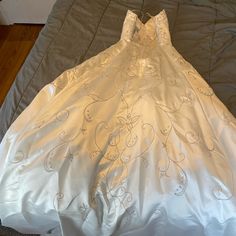 a white dress laying on top of a bed